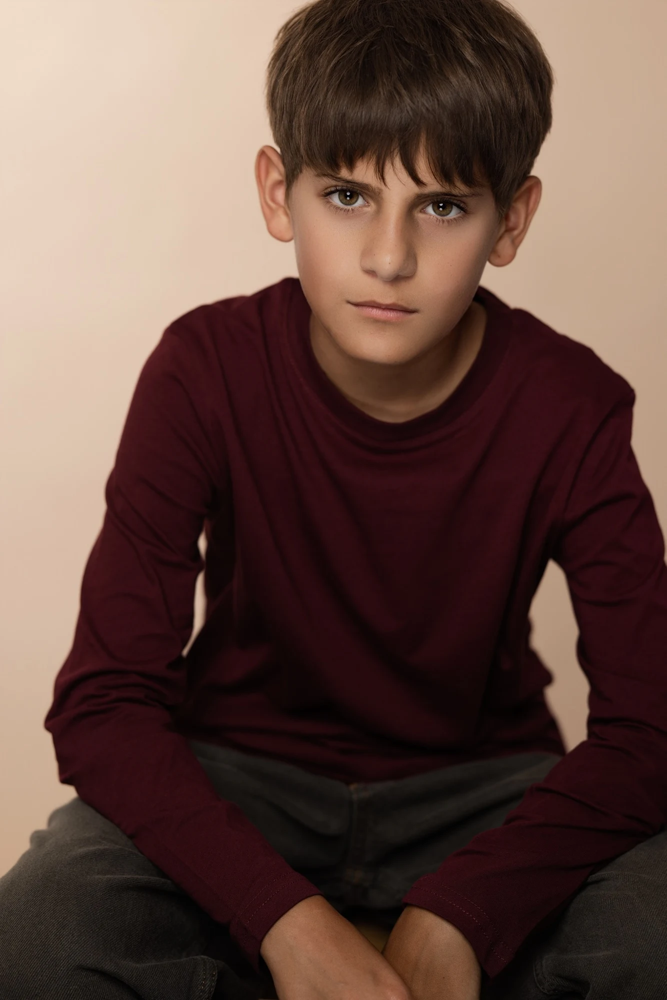 Brandon Antonik-Rodriguez in his burgundy theatrical headshot